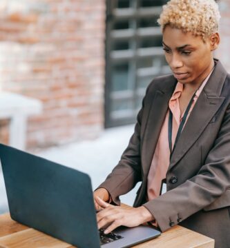 serious black businessman typing on laptop during remote work